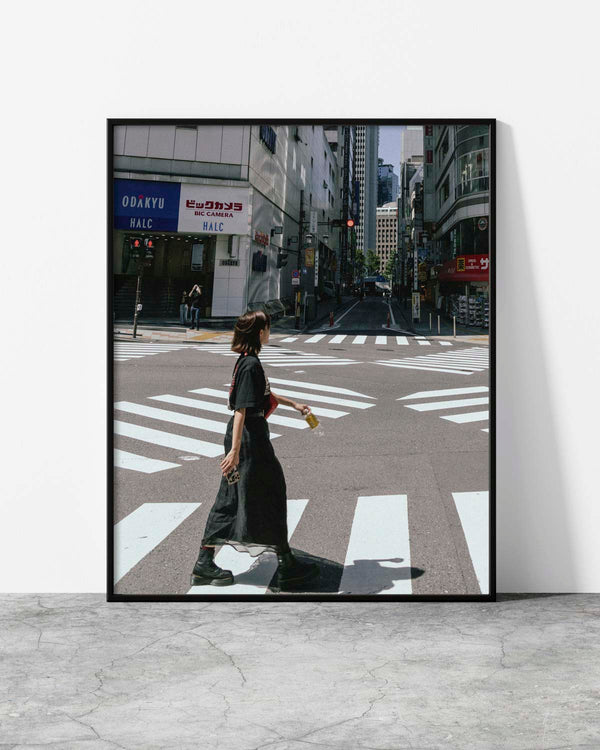 Urban street photography of a stylish woman crossing a city intersection with bold zebra stripes.