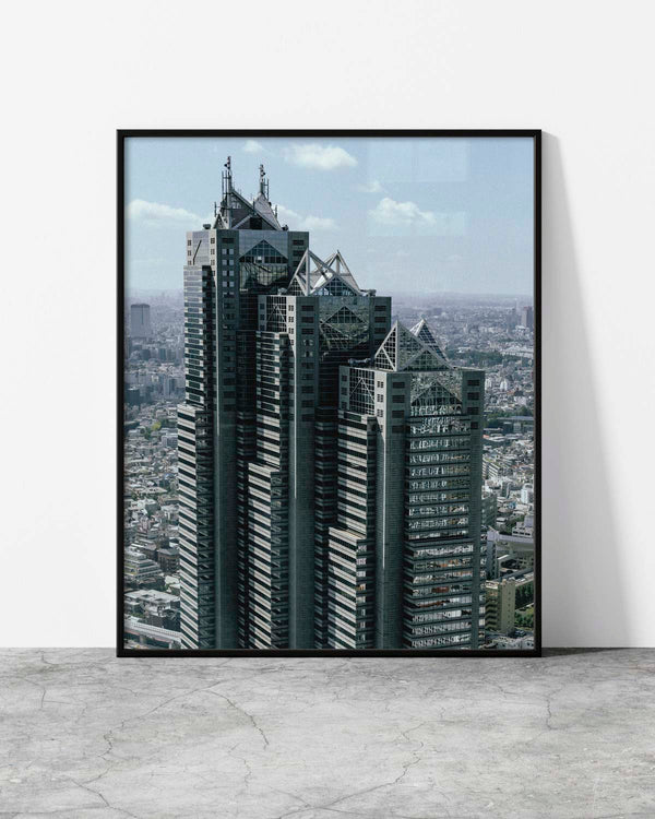 Urban wall art of a futuristic high-rise building towering over the dense Tokyo cityscape.