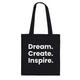 A black canvas tote bag designed by North Minimal featuring white letter text that reads "Dream. Create. Inspire.". The image shows the front of the tote bag with the text centered and clearly visible on the black background.