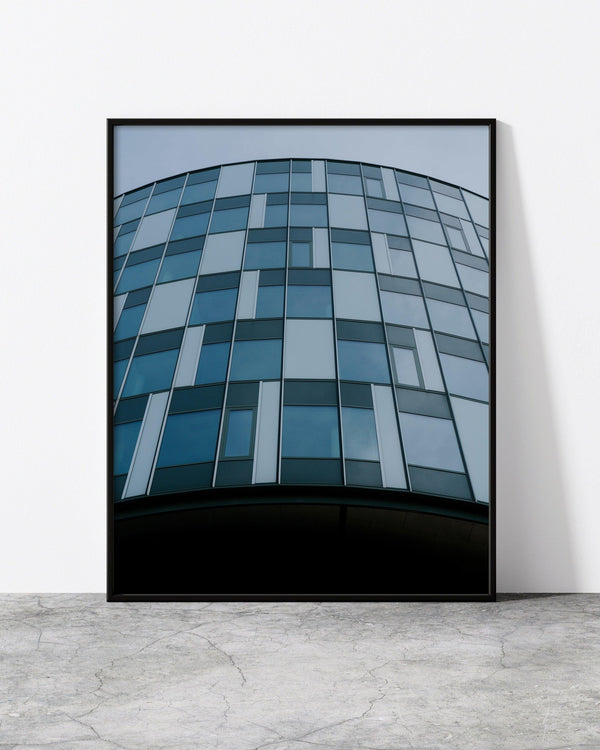 A minimalist photo print of modern architecture in Copenhagen, designed by North Minimal and displayed in a chic black frame. The photograph captures the striking geometric shapes and angles of the building, creating a visually captivating piece.