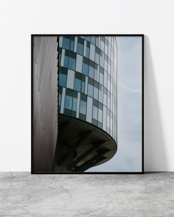 A contemporary architecture photo print designed by North Minimal, displayed in a sleek black frame. The image features a unique building in Copenhagen, characterized by clean lines and geometric shapes that showcase the beauty of simplicity.